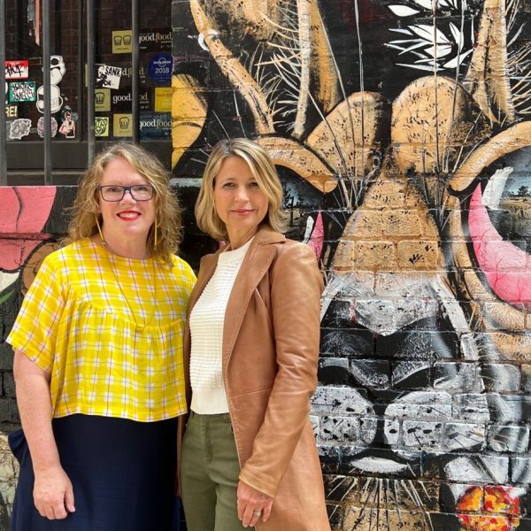 picture of Founder Fiona and Samanth Brown. in front of street art.