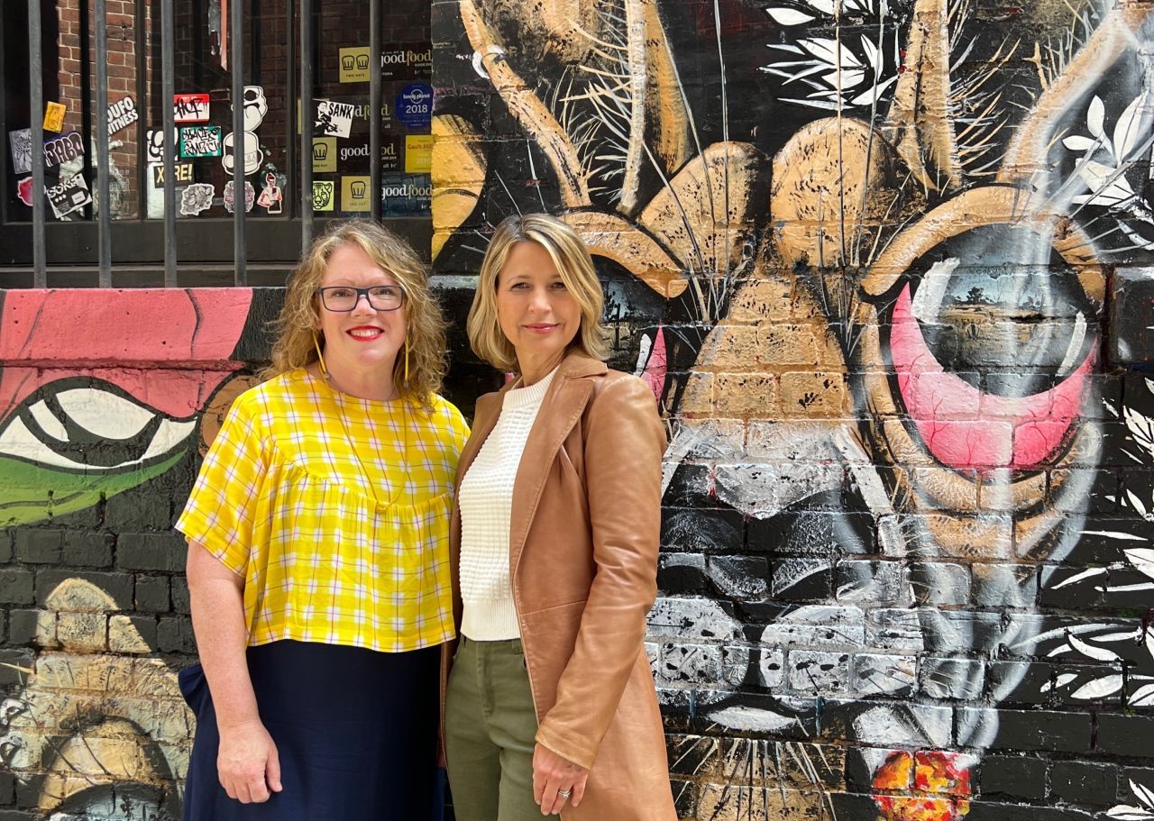 picture of Founder Fiona and Samanth Brown. in front of street art.